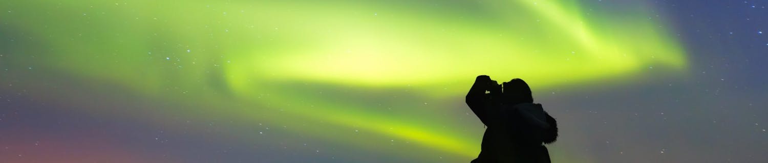 Silhouette,Of,Female,Photographer,Take,A,Photograph,At,Aurora,Borealis